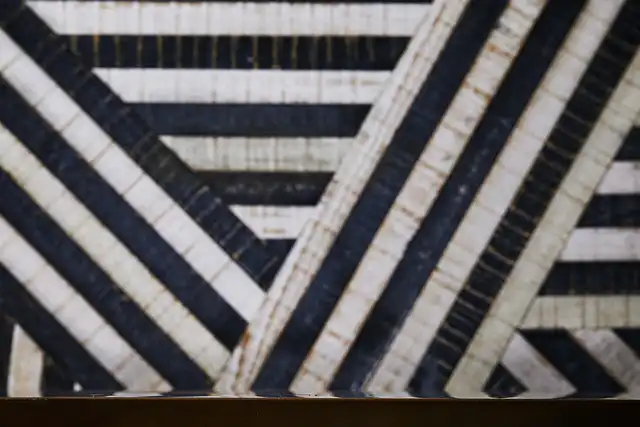 Close-up of a geometric pattern with diagonal black and white stripes, creating a bold, contrasting visual effect.