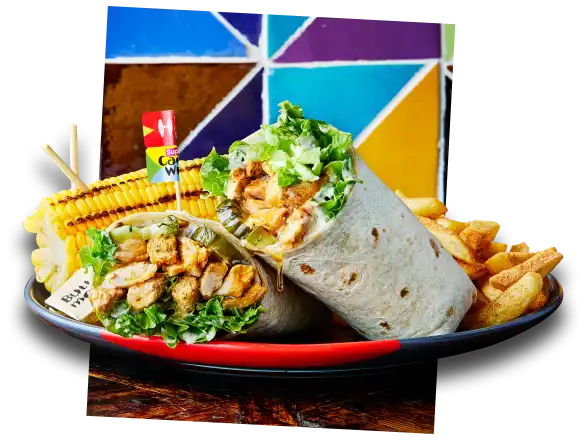 A plate with a chicken wrap, corn on the cob, and seasoned fries, set against a colorful geometric background.